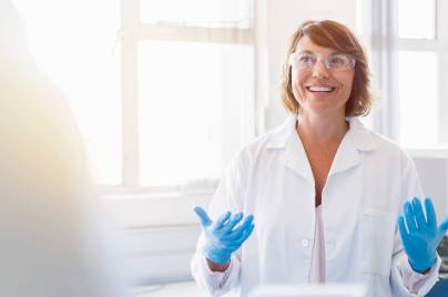 Happy chemist gesturing and talking in laboratory