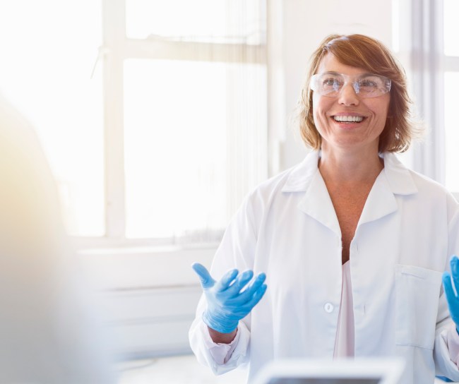 Happy chemist gesturing and talking in laboratory