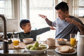 Father and son having breakfast in kitchen
